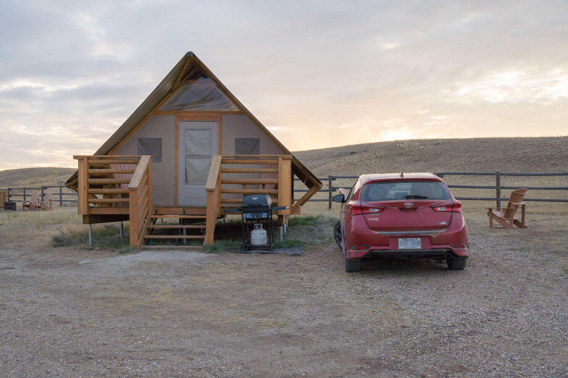 notre voiture à côté d'une tente en bois, un de nos logements lors de notre road trip d'1 mois au Canada